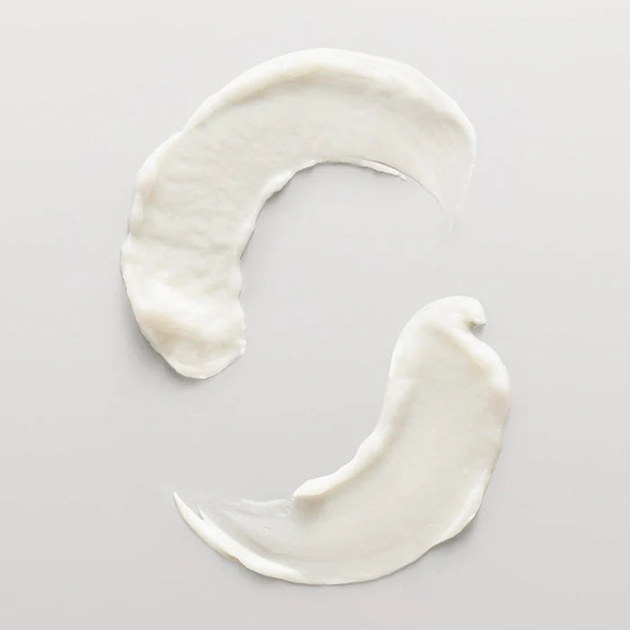 Two swirls of white cream on a light gray background
