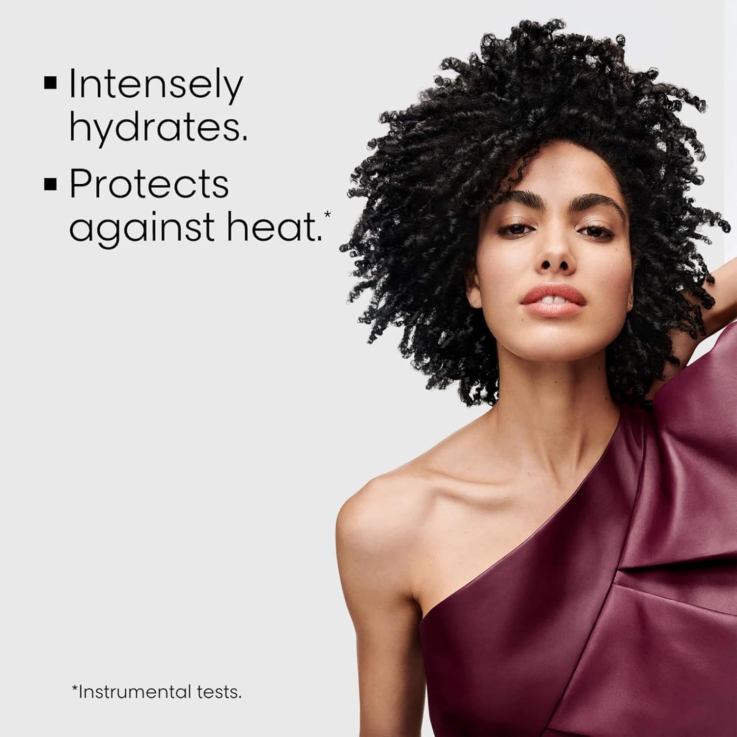 Woman with styled hair against a light gray background with text about product benefits.